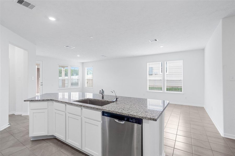 The central kitchen island features a durable granite countertop, an undermount stainless steel sink, with a Moen pull-down faucet. The kitchen island has additional storage space, increased counter and prep space, and is the social hub of the home--where family and guests gather and interact!