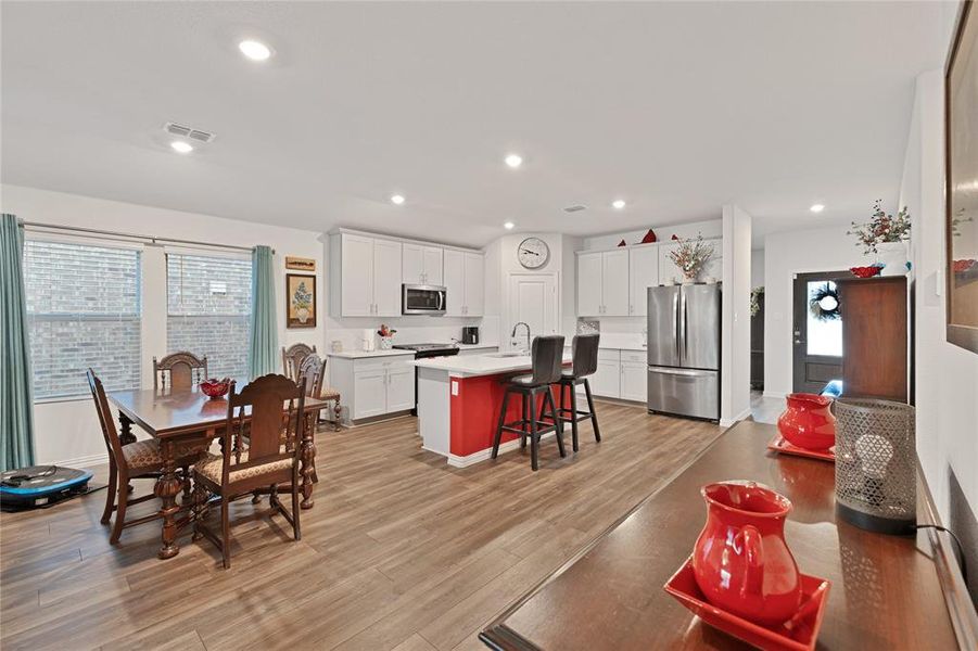 Dining space featuring light wood finished floors, visible vents, recessed lighting, and baseboards