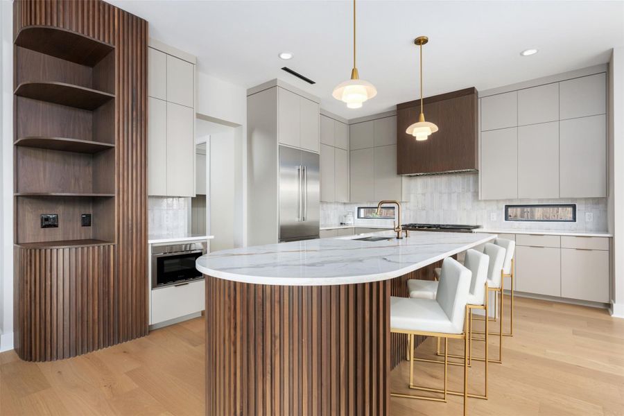 Oversized island with quartz counter, fluted wood, and 2 dishwashers. Oversized island with quartz counter, fluted wood, and 2 dishwashers.