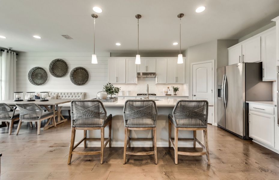 Spacious island kitchen with eat-in bartop and gorgeous pendant lighting