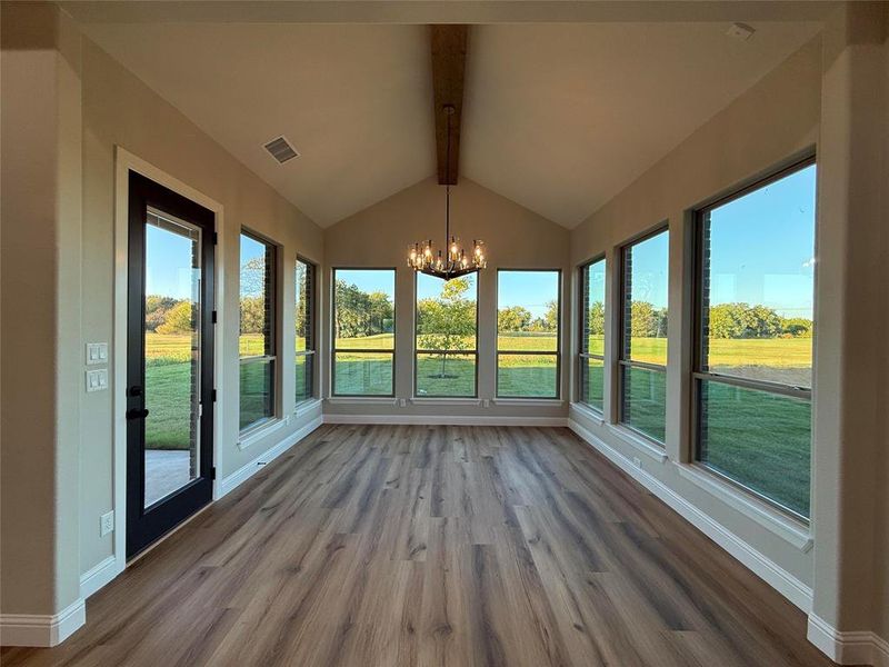 Unfurnished sunroom with wood finished floors and a chandelier Unfurnished sunroom with wood finished floors and a chandelier