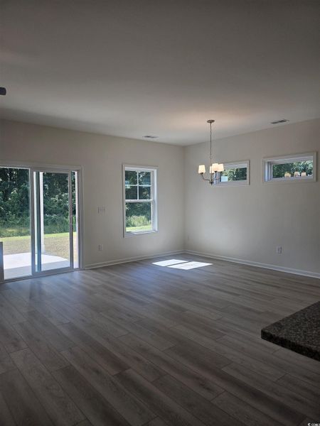 Unfurnished dining area with LVP floors and a chandelier