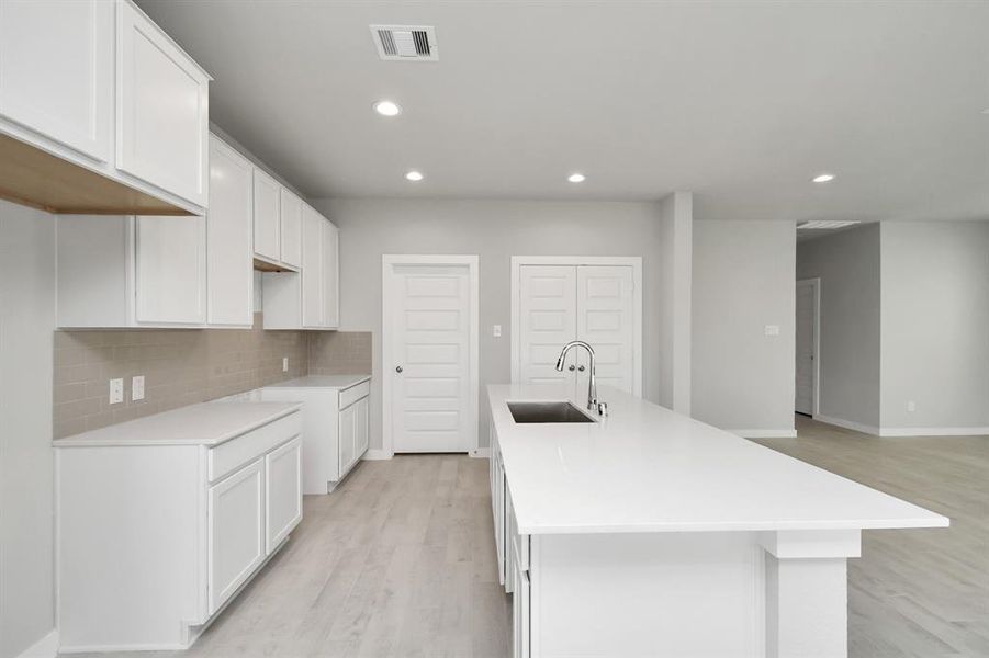 Discover another perspective of this stunning kitchen, generously appointed with an abundance of counter space