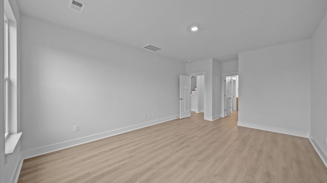 Superior design meets vibrant comfort in this primary suite with hardwood floors and walk-in closet Superior design meets vibrant comfort in this primary suite with hardwood floors and walk-in closet