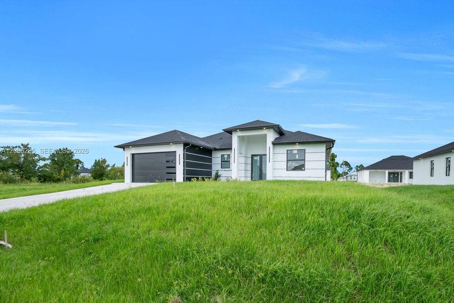 Front exterior of a new home in , Lehigh Acres, FL, highlighting curb appeal (Image 19).