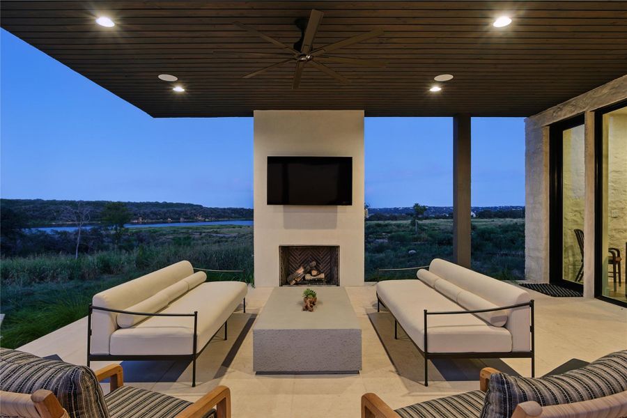 View of patio featuring an outdoor living space with a fireplace and a ceiling fan