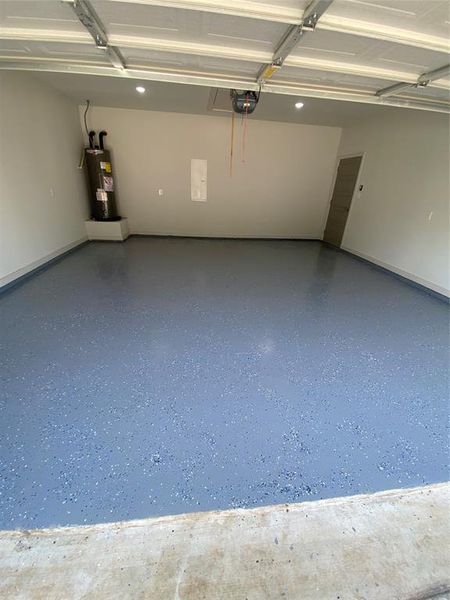 Garage featuring water heater and a garage door opener Garage featuring water heater and a garage door opener