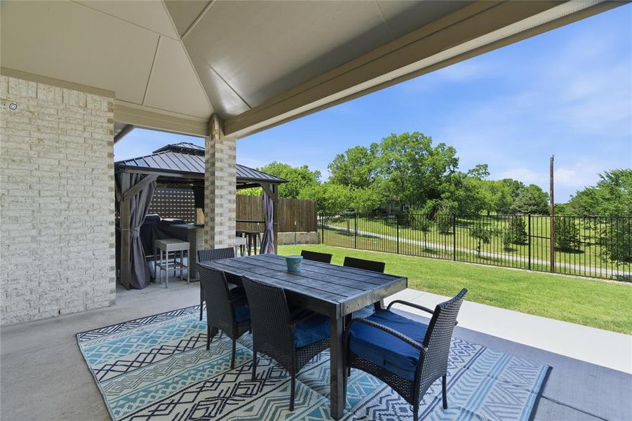 Expansive covered patio featuring a concrete surface and a white brick-clad support column