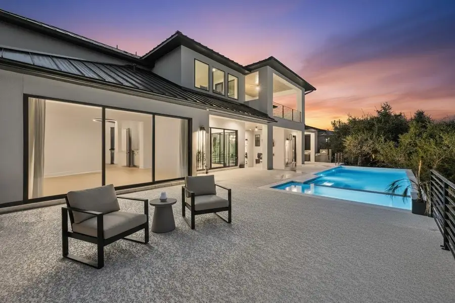 Contemporary exterior with a metal roof, expansive patio, integrated swimming pool, and multiple large sliding glass doors