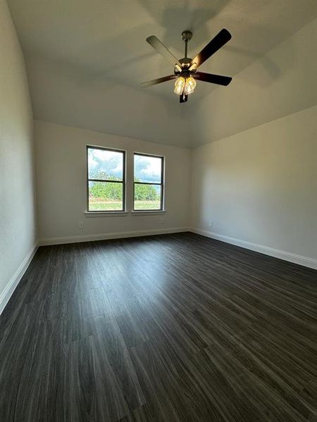 Unfurnished room featuring ceiling fan, dark wood-type flooring, and vaulted ceiling