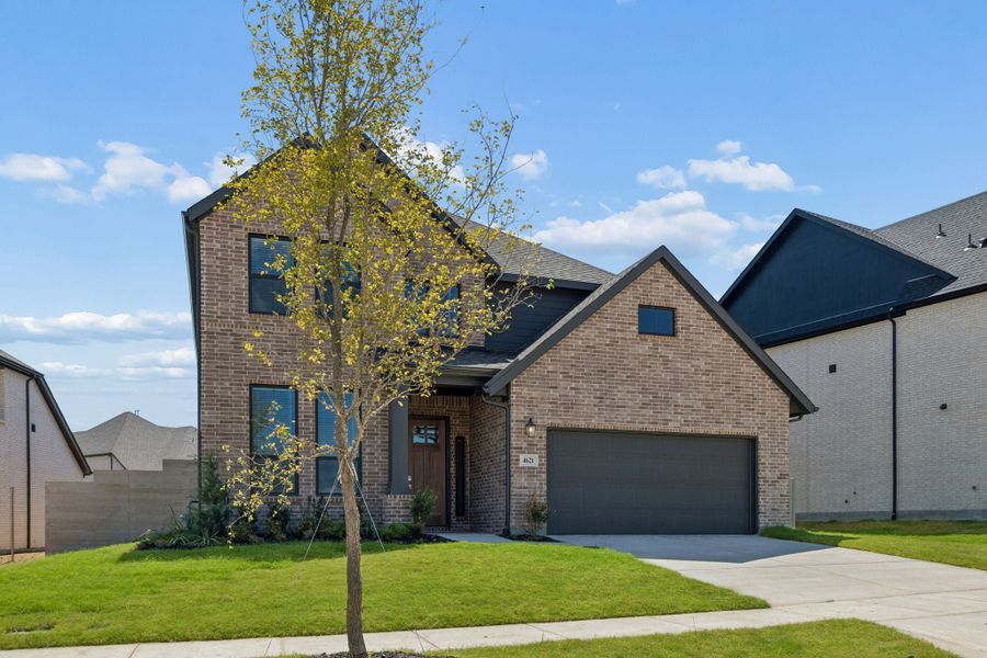 Front exterior of a new home in Painted Tree Woodland West, McKinney, TX, highlighting curb appeal (Image 2). Front exterior of a new home in Painted Tree Woodland West, McKinney, TX, highlighting curb appeal (Image 2).