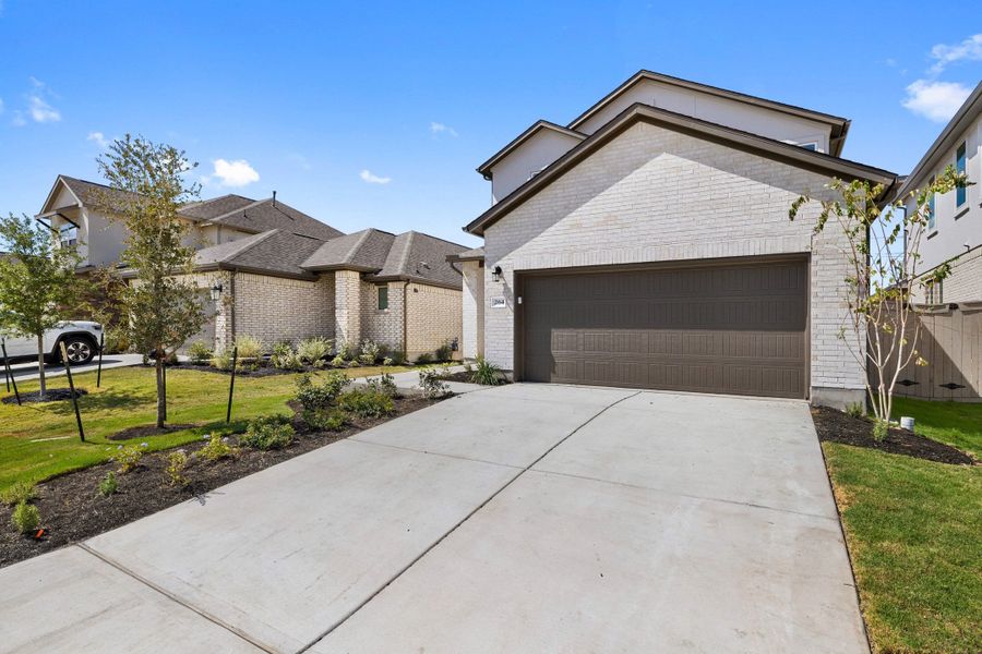 Front exterior of a new home in Flora, Hutto, TX, highlighting curb appeal (Image 26).