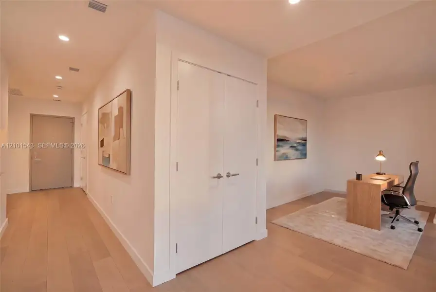 Interior space featuring wood-finish flooring, recessed lighting, and double-door closet cabinetry