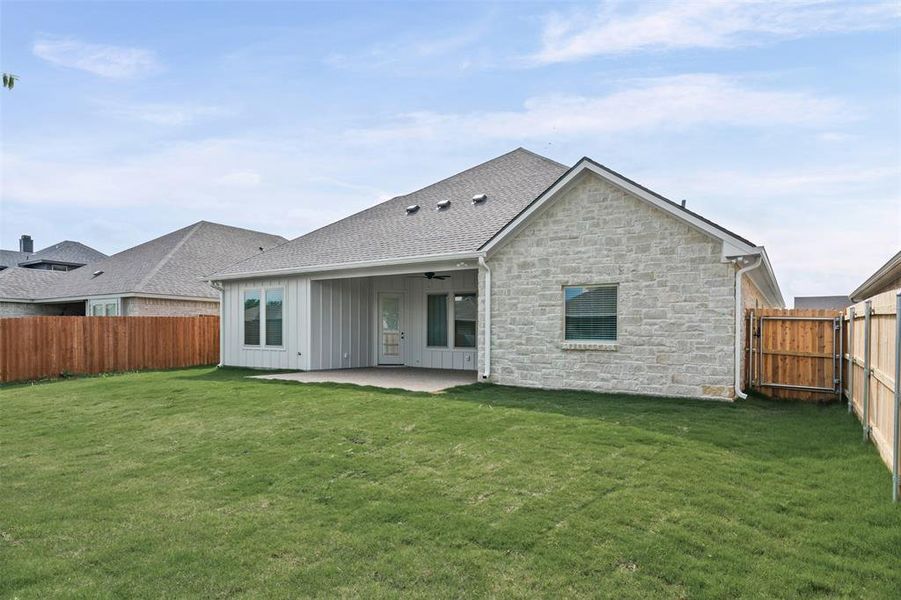 The property features a spacious backyard with a well-maintained lawn and a covered patio area