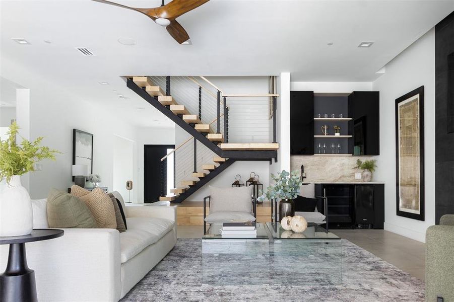 Living room with built in features and ceiling fan