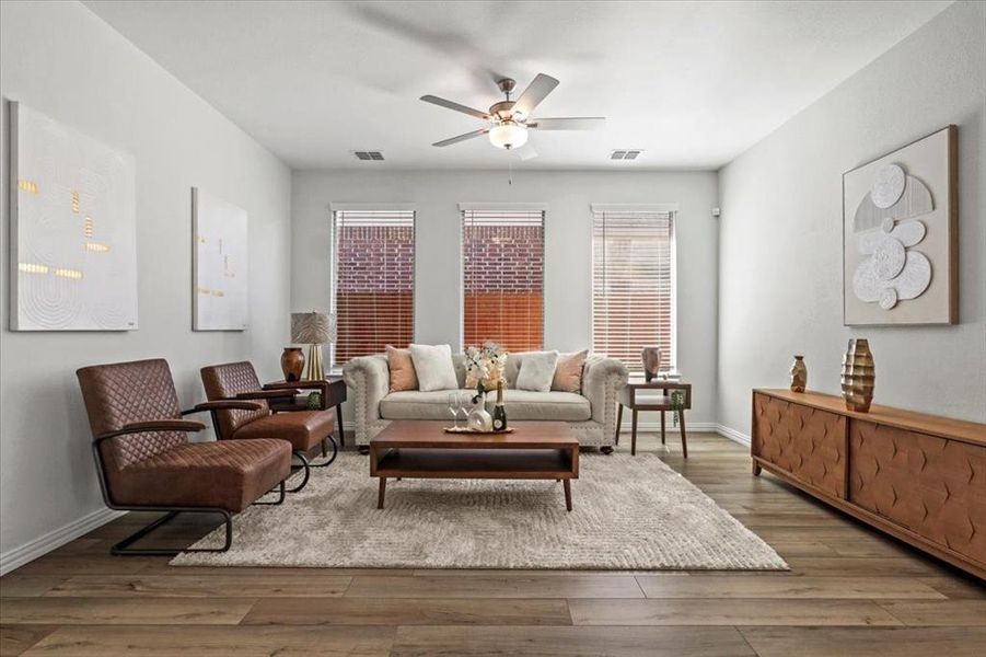 Living area featuring wood finished floors and a ceiling fan Living area featuring wood finished floors and a ceiling fan