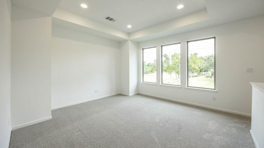 Unfurnished room featuring light colored carpet, a raised ceiling, and recessed lighting Unfurnished room featuring light colored carpet, a raised ceiling, and recessed lighting