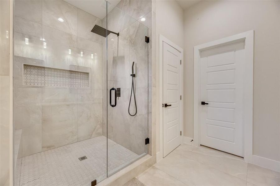 Bathroom featuring a shower stall and baseboards Bathroom featuring a shower stall and baseboards