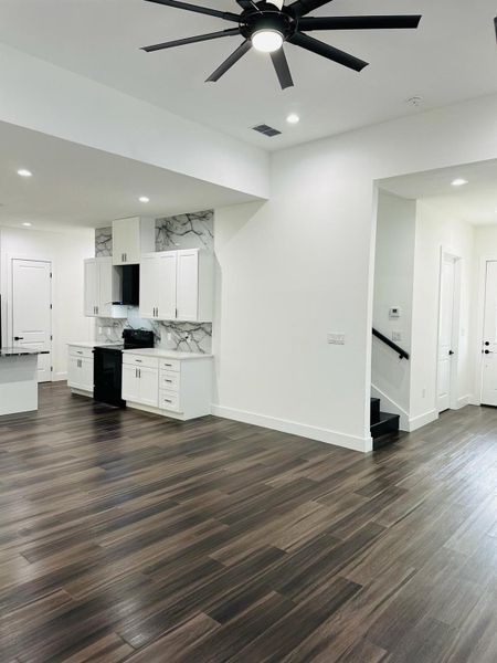 Unfurnished living room with ceiling fan, dark wood-type flooring, and recessed lighting Unfurnished living room with ceiling fan, dark wood-type flooring, and recessed lighting