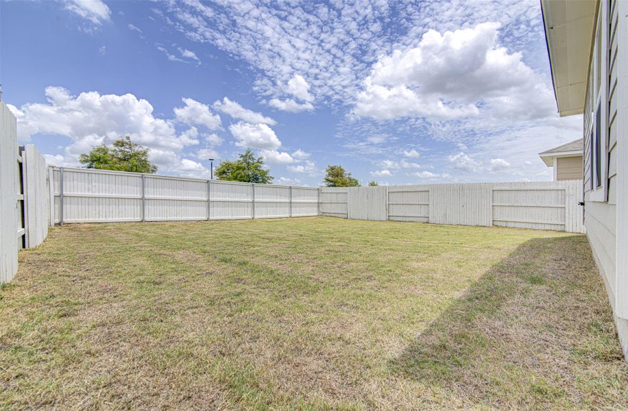 A spacious backyard enclosed by a secure wooden fence, offering ample outdoor living potential. A spacious backyard enclosed by a secure wooden fence, offering ample outdoor living potential.