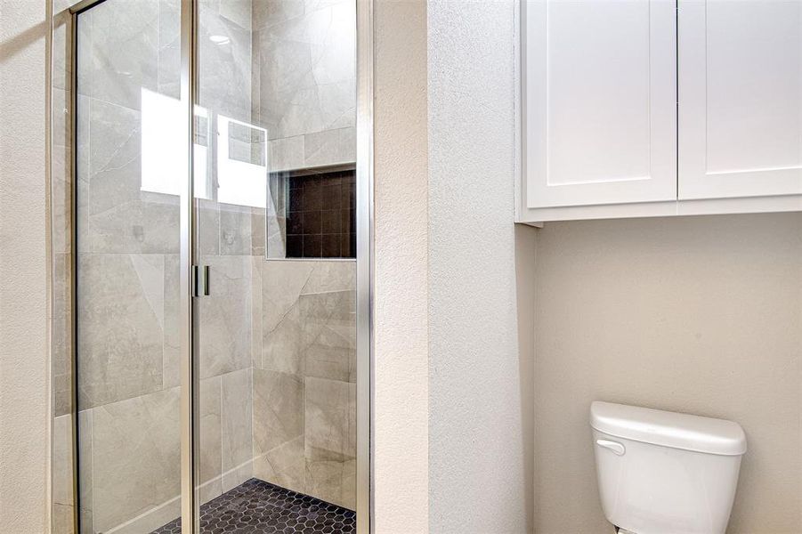 Bathroom with toilet and a shower with shower door