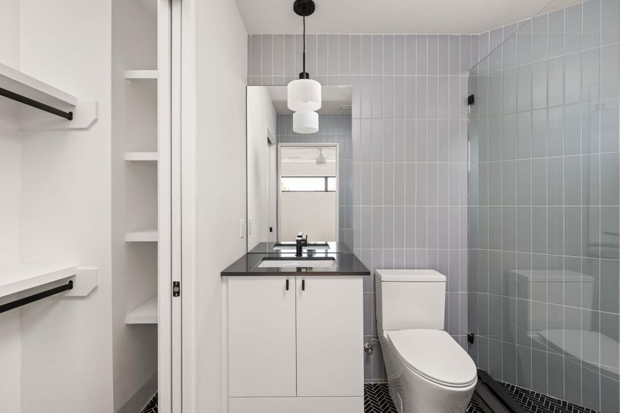 Full bath featuring vanity and tile walls