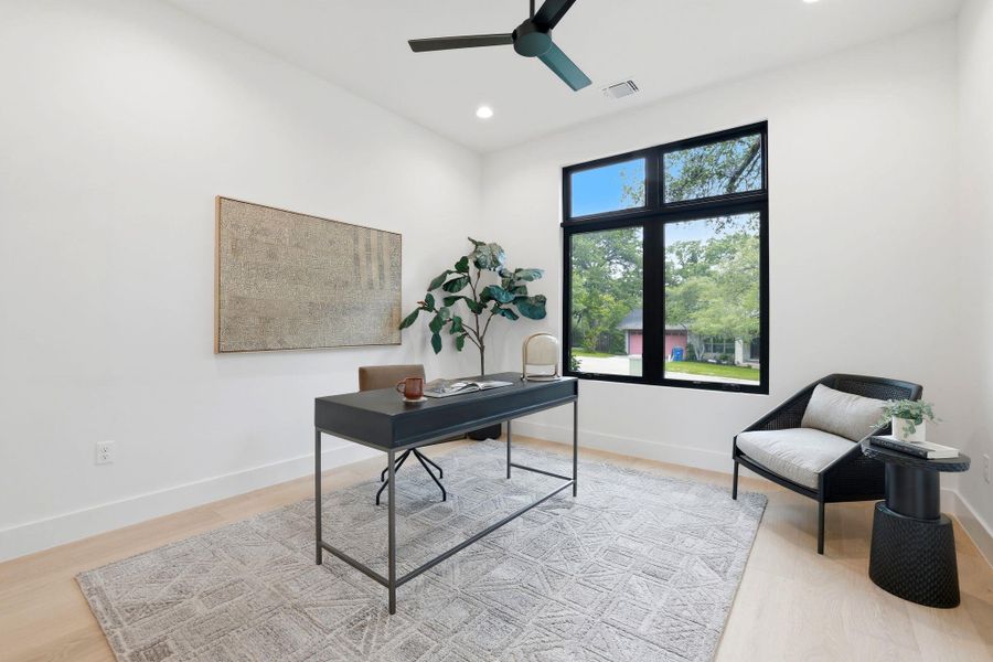 Bright room featuring light wood-finish flooring and a large black-framed window