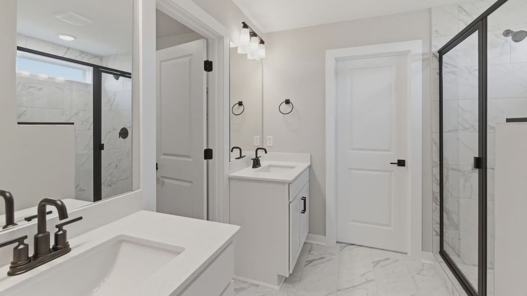 Bathroom with dual vanity and access to primary closet