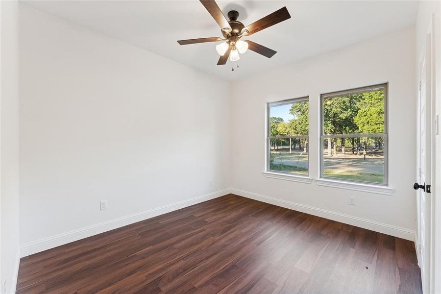 Unfurnished room with dark wood finished floors and a ceiling fan