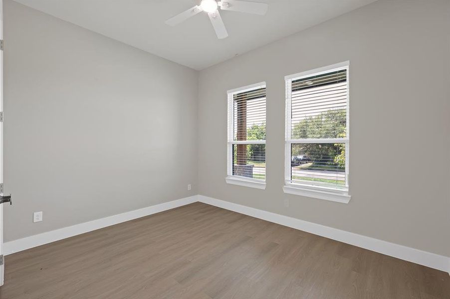 Empty room featuring baseboards, wood finished floors, and a ceiling fan