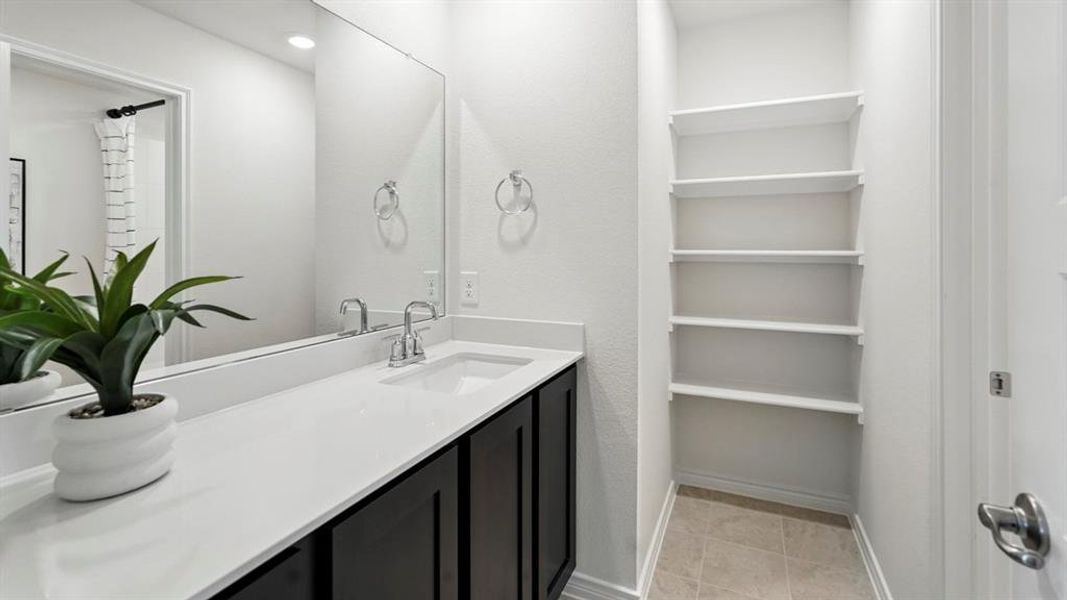 Full bath featuring vanity and light tile patterned floors