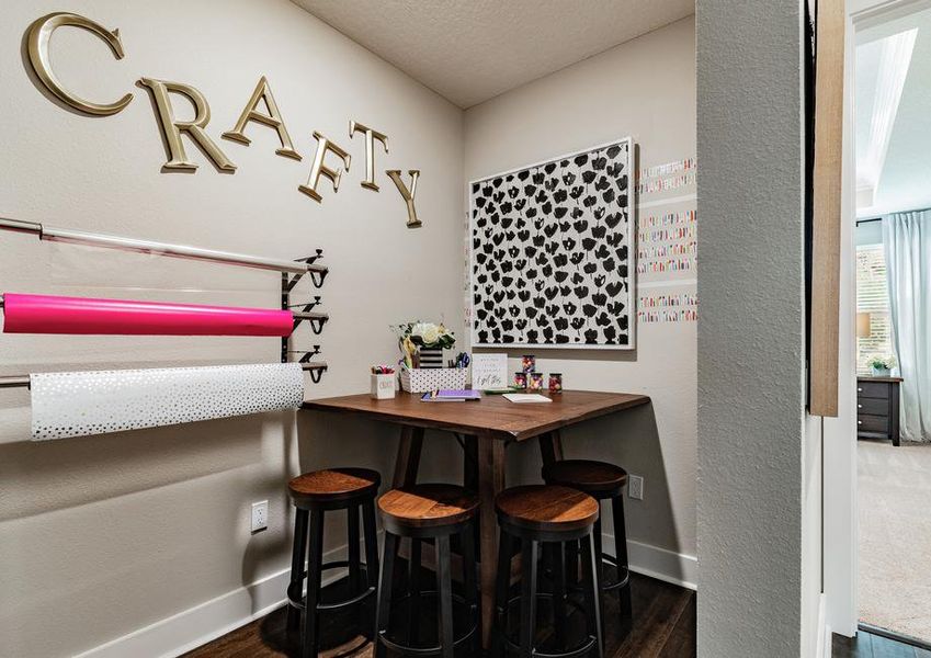 Craft room with a table, stools and art supplies.