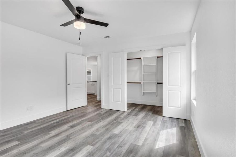 Unfurnished bedroom featuring ceiling fan, a closet, and wood-type flooring