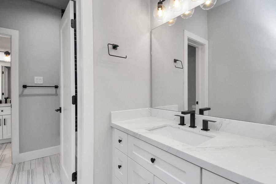 Jack-and-Jill guest bathroom with modern finishes and sleek fixtures. Functional layout offering convenience and style for shared use.