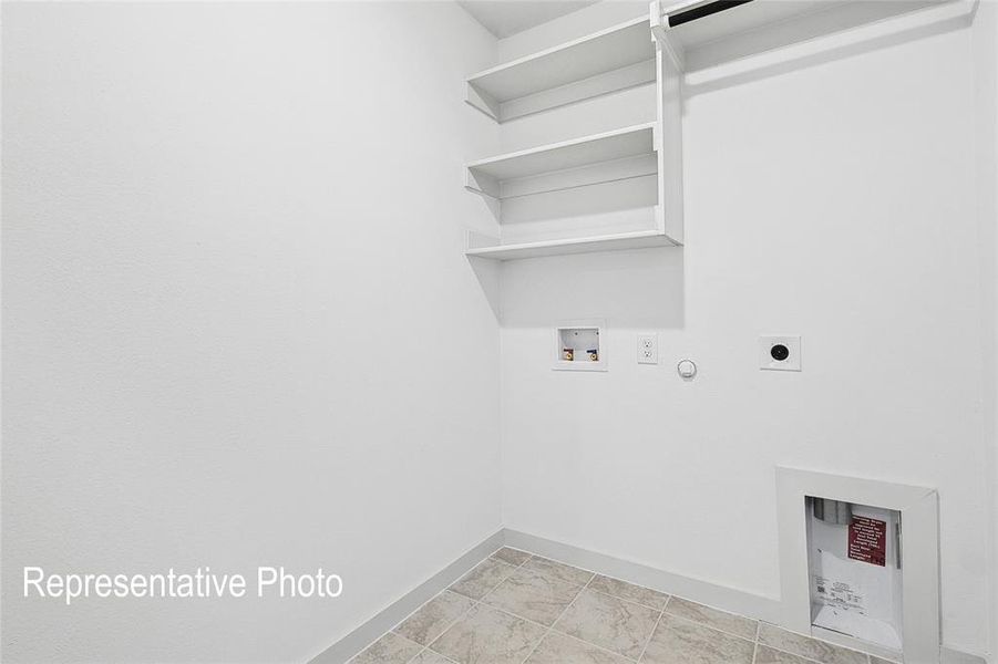 Laundry area featuring built-in shelving, a clothes rod, utility connections, and neutral-toned floor tiling
