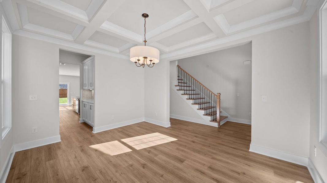 Desirable dining room with coffered ceiling and modern elegance in an established community Desirable dining room with coffered ceiling and modern elegance in an established community