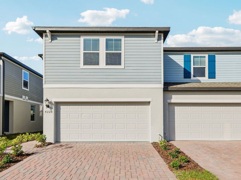 Front exterior of a new home in The Meadow at Crossprairie Townes, St. Cloud, FL, highlighting curb appeal (Image 1). Front exterior of a new home in The Meadow at Crossprairie Townes, St. Cloud, FL, highlighting curb appeal (Image 1).