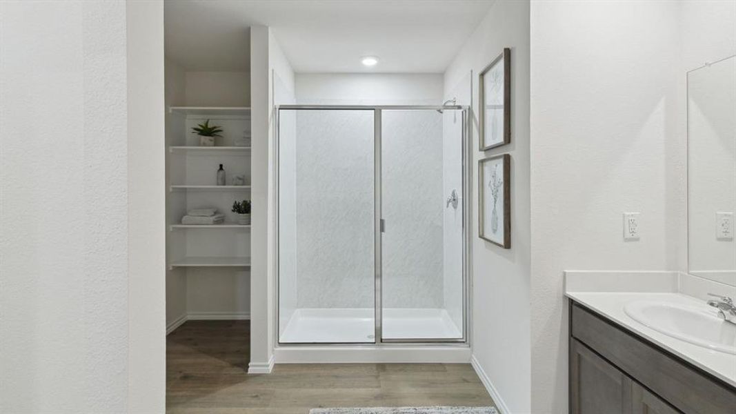 Full bath with vanity, light wood-type flooring, and a stall shower Full bath with vanity, light wood-type flooring, and a stall shower