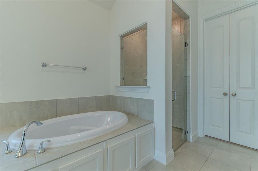 Deep soaking tub with polished chrome fixtures set within a tiled surround