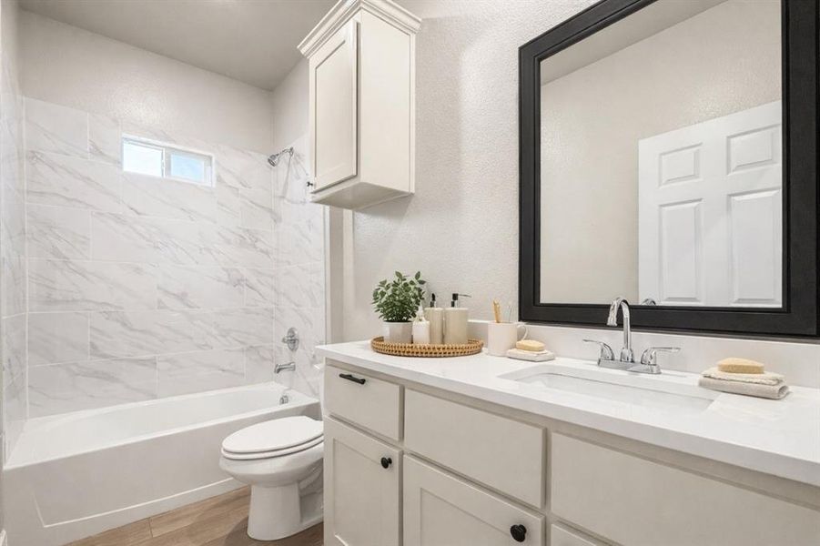 Bathroom with vanity, bathing tub / shower combination, and light wood-type flooring