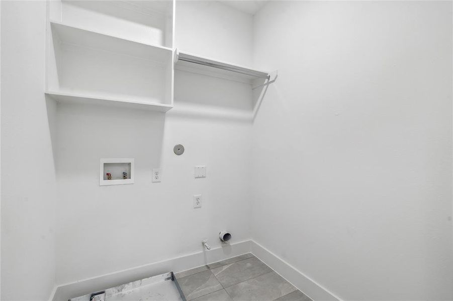 Walk-in utility room with built in shelving for ultimate functionality.