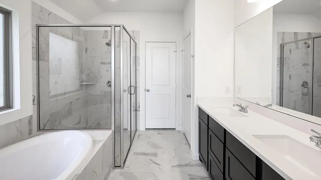 Full bath with a garden tub, a marble finish shower, double vanity, and light marble finish floors Full bath with a garden tub, a marble finish shower, double vanity, and light marble finish floors