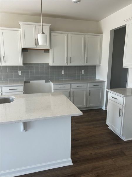 This bright kitchen features sleek countertops and