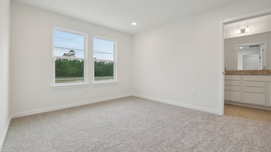 Primary suite with en suite Bath of the Coronado - End at Cyrene at Harmony located in St Cloud FL by DRB Homes Primary suite with en suite Bath of the Coronado - End at Cyrene at Harmony located in St Cloud FL by DRB Homes