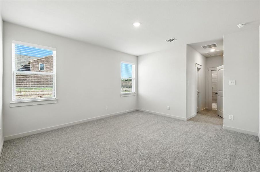 Empty room with healthy amount of natural light, light carpet, and recessed lighting Empty room with healthy amount of natural light, light carpet, and recessed lighting