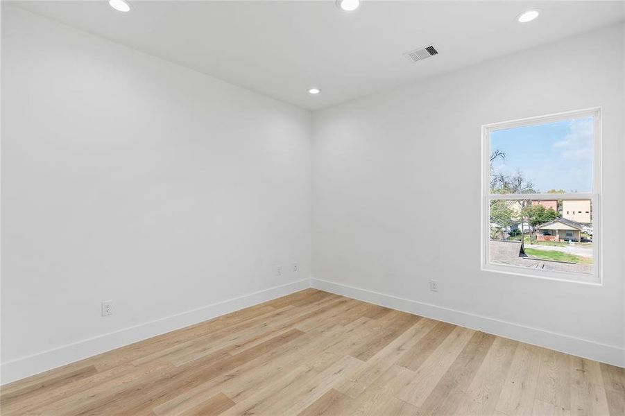 An alternate perspective of the secondary bedroom reveals a large window, welcoming abundant natural light into the space, enhancing its inviting ambiance and highlighting its charm.