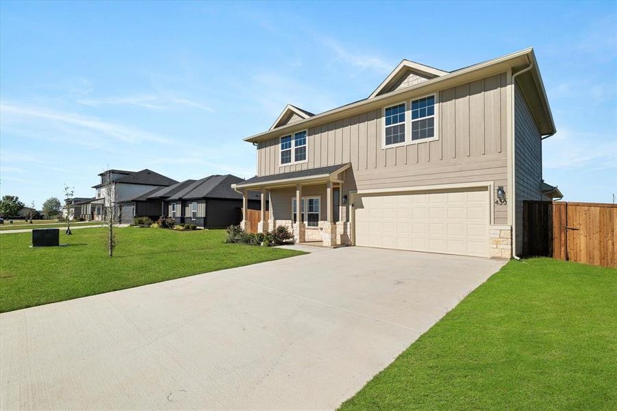 View of front of home with a porch, a garage, and a front lawn View of front of home with a porch, a garage, and a front lawn