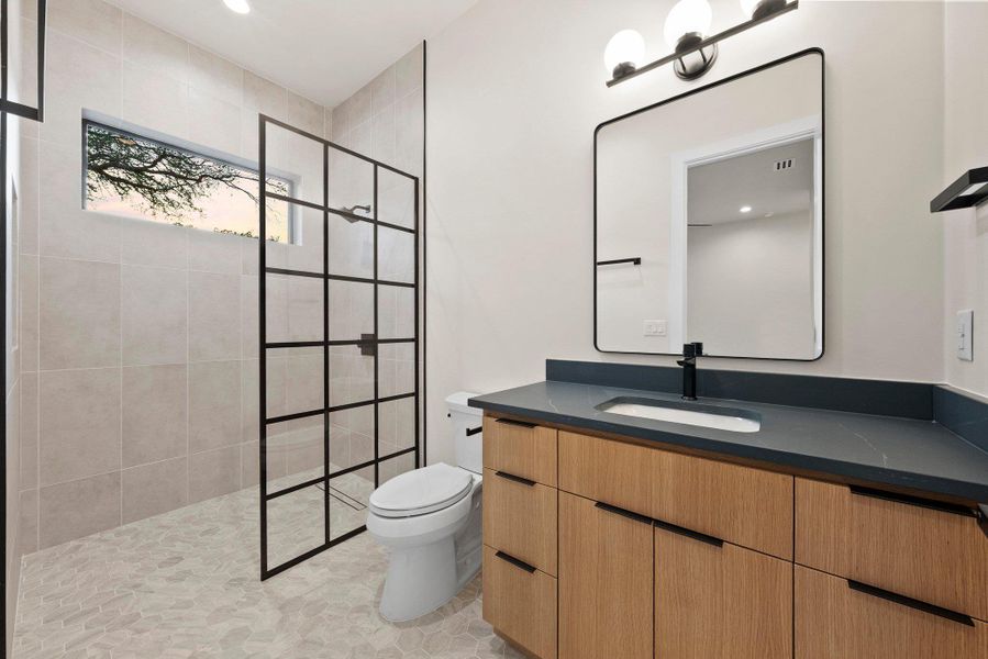 A well-appointed bathroom offers a modern vanity, sleek shower, and ample natural light.