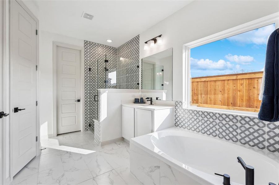 Bathroom with vanity and shower with separate bathtub