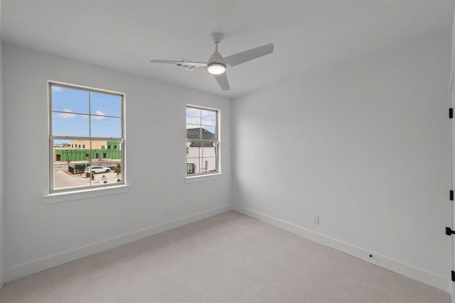 Spare room with ceiling fan and light carpet